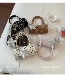 Vue détaillée de sacs cylindriques tendance à pois avec breloques étoile argentées multiples.
