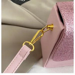 Detail view of the pink glitter flap handbag featuring gold-tone metal clasp and leather strap.