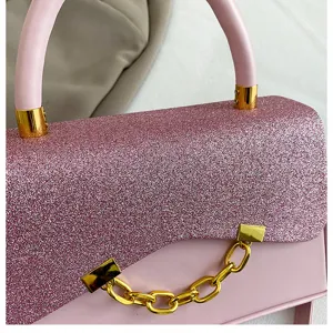 Pink glitter detail handbag, elegant asymmetric flap with luxury gold chain hardware.