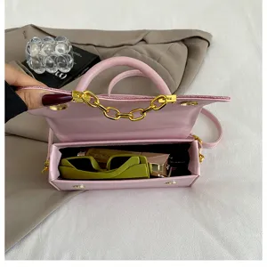 Pink PU leather small square bag detail showing interior space and gold chain strap design.