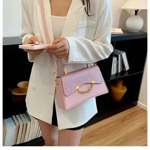 Detailed view of the pink glitter crossbody bag with chic chain ornament and elegant strap.
