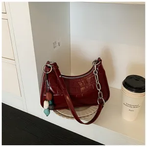 Red crocodile pattern leather underarm shoulder bag with chunky metal chain and charms.