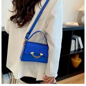 Blue glitter flap shoulder bag close-up, stylish chain decor, elegant crossbody design.