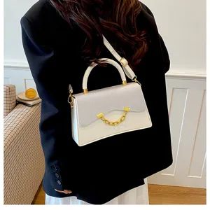 Detailed view of the stylish white square shoulder bag with glitter flap and gold chain accent.