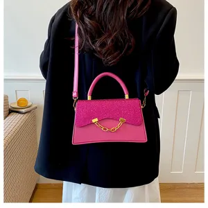 Chic pink glitter crossbody handbag, stylish detail view showcasing metallic chain accent.