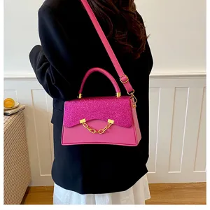 Pink glitter flap crossbody bag detail, stylish gold chain accent, elegant handbag lifestyle view.
