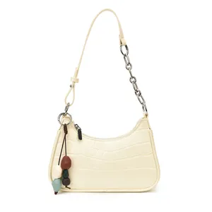 Chic cream crocodile pattern shoulder bag with metal chain strap and cute beaded charm.