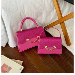 Detail view of stylish pink glitter flap crossbody handbag with elegant gold chain link hardware.