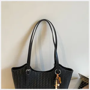 Borsa a spalla intrecciata nera vista dettaglio, design casual minimalista classico elegante.