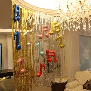 Tinsel fringe curtain with musical note foil balloons for birthday party backdrop decoration