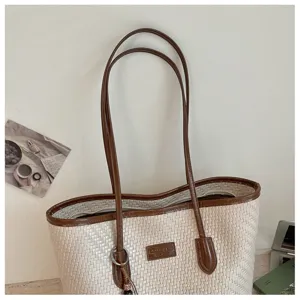 Sac cabas tissé beige élégant pour femme avec bordure en cuir marron et grande capacité de rangement.