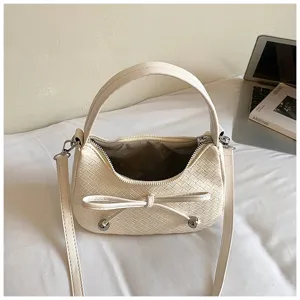 Beige woven crescent shoulder bag, stylish PU leather handbag with chic bow detail for women.