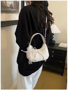 Exquisite white woven crescent shoulder bag detail, chic bow and elegant pearl charms.
