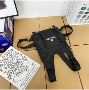 Nahaufnahme der schwarzen taktischen Brusttasche mit robusten Gurten und praktischen Fächern.