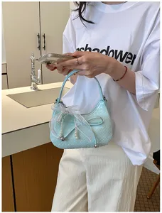 French woven crescent underarm bag with elegant pearl bow charm, stylish solid color shoulder bag.