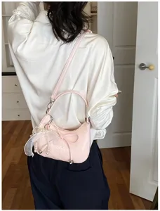 Pink woven hobo shoulder bag detail featuring pearl ribbon bow accent and compact shape.