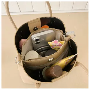 Detail view of the spacious interior and organized storage of the beige bucket bag.