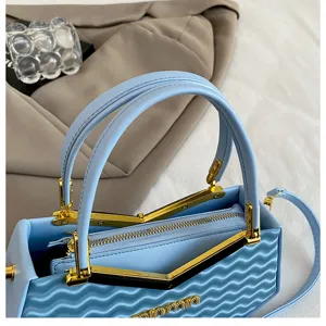 Primo piano sui dettagli della borsa azzurra, hardware dorato, scomparto con zip.