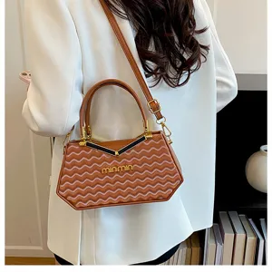 Dettaglio borsa a mano con motivo a onde, elegante borsa a tracolla marrone per donna.