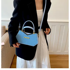 Vista dettagliata della borsa a mano azzurra con trama ondulata, manico in metallo e design chic.