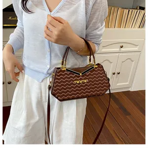 Vista dettagliata della borsa marrone con motivo ondulato, dettagli e design chic.