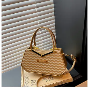 Borsa a mano geometrica color champagne con manico in metallo e tracolla elegante per le donne.