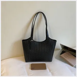 Presentazione dettagliata di un'elegante borsa a tracolla chic in pelle intrecciata nera.