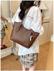 Vista dettagliata della borsa tote in pelle intrecciata marrone con lavorazione artigianale.