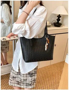 Vista dettagliata della borsa a spalla in pelle intrecciata nera, elegante e chic.