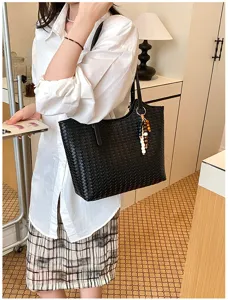 Vista dettagliata della borsa tote in pelle nera intrecciata, mostrando la tessitura.