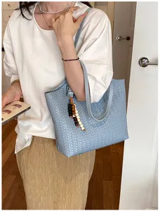 Borsa tote spalla in pelle intrecciata blu dettaglio su modella, accessorio elegante