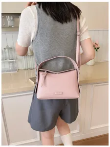 Pink leather crossbody bag for women, stylish top handle shoulder bag for casual summer daily use.