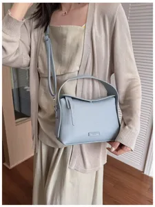 Detailed view of the stylish light blue leather shoulder bag, showcasing premium texture and design.