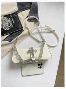 Weisse Leder-Achseltasche mit klobiger silberner Kette und funkelndem Strasskreuz.