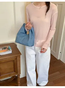 Nahaufnahme und Detailansicht einer stilvollen blauen Jeanshandtasche im Alltag.