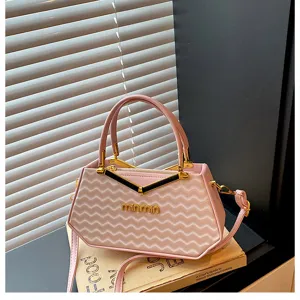 Vista dettagliata della borsa da donna rosa alla moda con motivo a onde e metallo dorato.