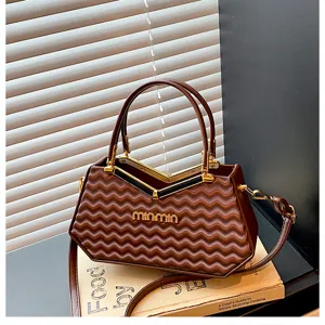 Primo piano dettagliato della borsa elegante con motivo a onde e fibbia in metallo.