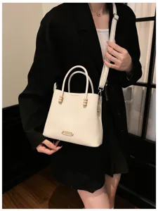 Elegant white bucket bag with top handle and shoulder strap for women daily commuting style.