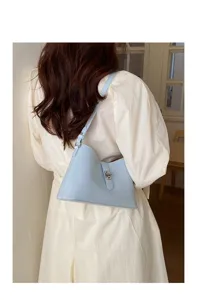 Borsa a tracolla minimalista azzurro chiaro sotto le braccia con chiusura metallica.