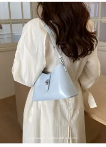 Vista dettagliata di una borsa a spalla minimalista azzurro chiaro con chiusura metallica.