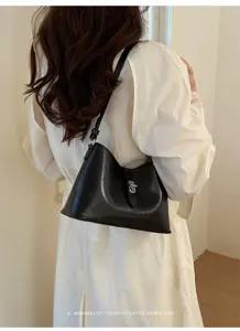 Borsa a spalla nera minimalista con dettaglio di chiusura in metallo per il lavoro.