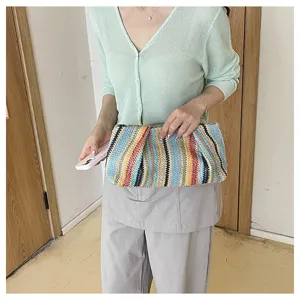 Colorful woven straw clutch bag detail view, showing unique rainbow stripe design for summer style.