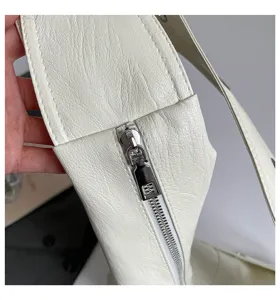 White faux leather shoulder bag detail, stylish retro motorcycle tote with metal zipper.