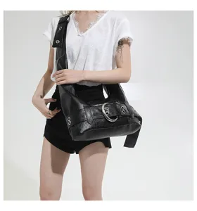 Black faux leather shoulder hobo bag featuring metal buckle and stylish grommet detail.