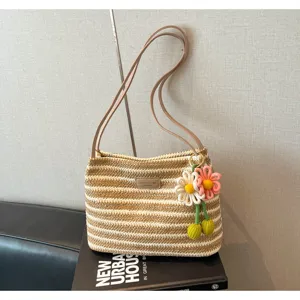 Gevlochten schoudertas van stro voor dames, stijlvolle gestreepte strandtas met bloemenhang.
