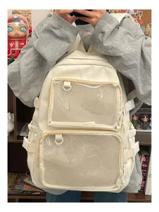Detail view of the beige ita backpack showcasing front clear mesh pockets, D-rings and sturdy straps.