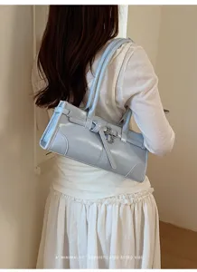 Vista dettagliata di una chic borsa a spalla azzurra con fibbia e cinturino retrò.