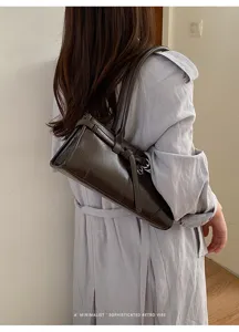 Vista dettagliata della borsa a spalla da donna in pelle marrone scuro con cinturino.