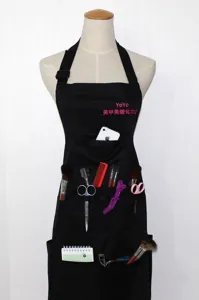 Black canvas work apron with multiple pockets and custom text print, ideal for salon and cafe.