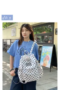 Stylish black and white polka dot backpack with flap and drawstring, casual casual daypack.